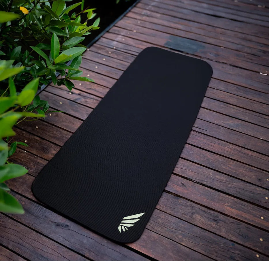 NIVɅYS black sustainable eco‑friendly yoga mat on wooden deck for yoga and workouts
